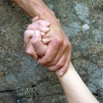 Picture of two arms with hands holding
