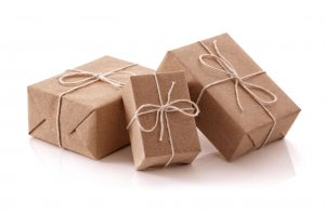 Three boxes wrapped in brown paper and tied with bows