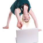 Photo of woman doing a backbend and touching a laptop