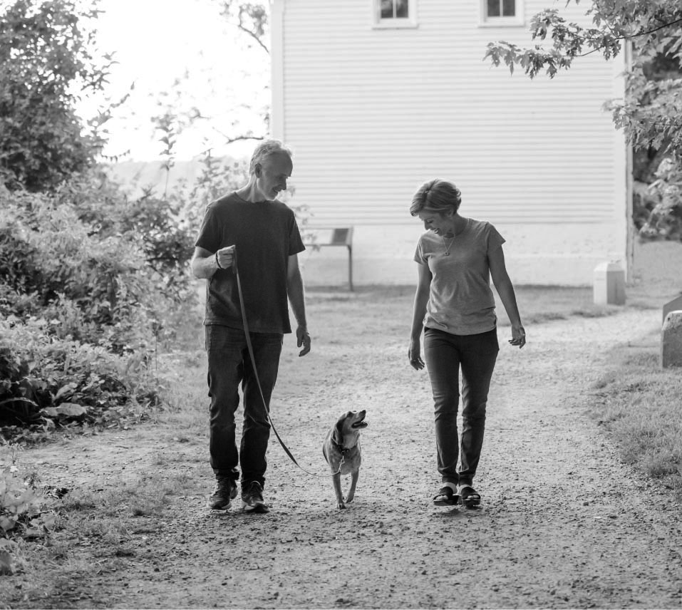 man and woman walking dog