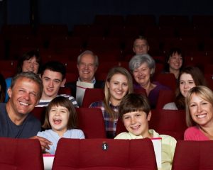 A group of people, adults and children, in an audience. 